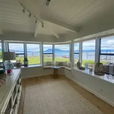 A room with large windows and a view of the ocean.